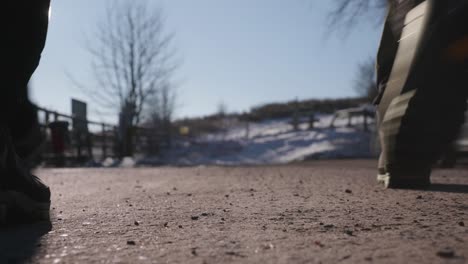 Two-people-walking-past-and-away-from-a-low-angle-shot-on-a-winter-path