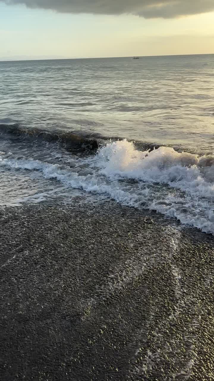 Onde dell'oceano che si infrangono su una spiaggia sabbiosa al tramonto