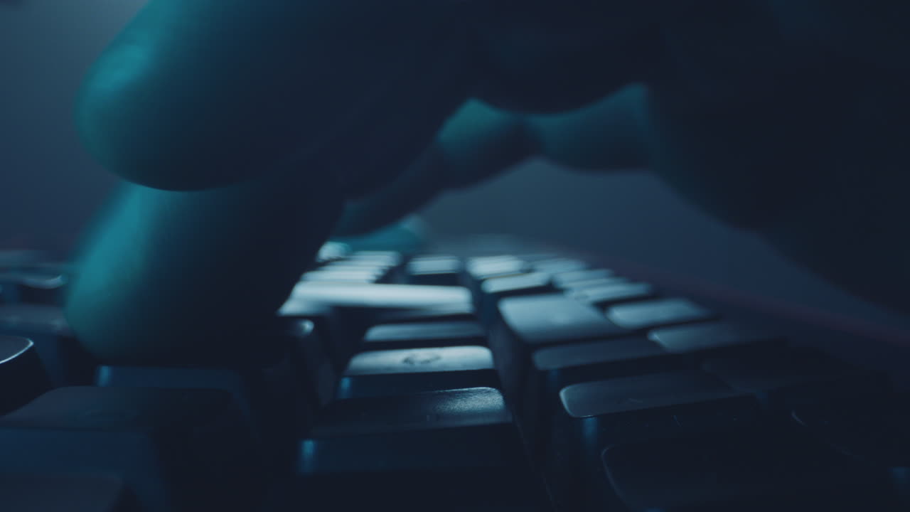 Nærbillede af hænder, der taster på et tastatur om natten