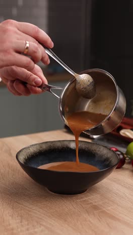 chef pouring sauce into a bowl