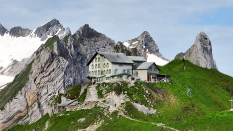 schafler mountain cabin with rocky mountain views in the early morning in switzerland. - aerial shot