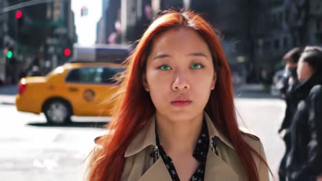 a young woman with striking red hair walks through a bustling city street filled with pedestrians and yellow taxis under bright sunshine, radiating confidence and style.