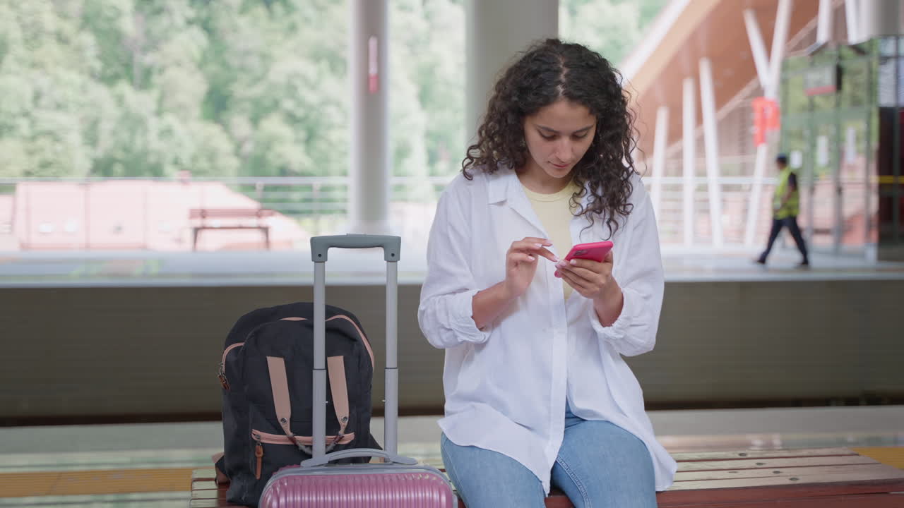 Woman using phone at train station