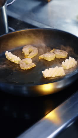 some seafood is fried on the frying pan. cooking prawns and sea scallops. close up. vertical video.