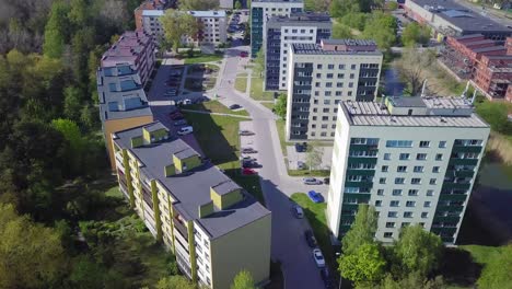 aerial birdseye view of crowded residential district apartment buildings on a sunny summer day, renovated and insulated houses, colorful walls of the facade, wide angle drone dolly shot moving right