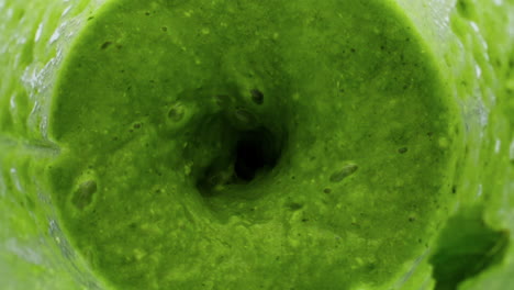 Closeup-green-vegetable-puree-preparing-in-blender-top-view.-Organic-blend.