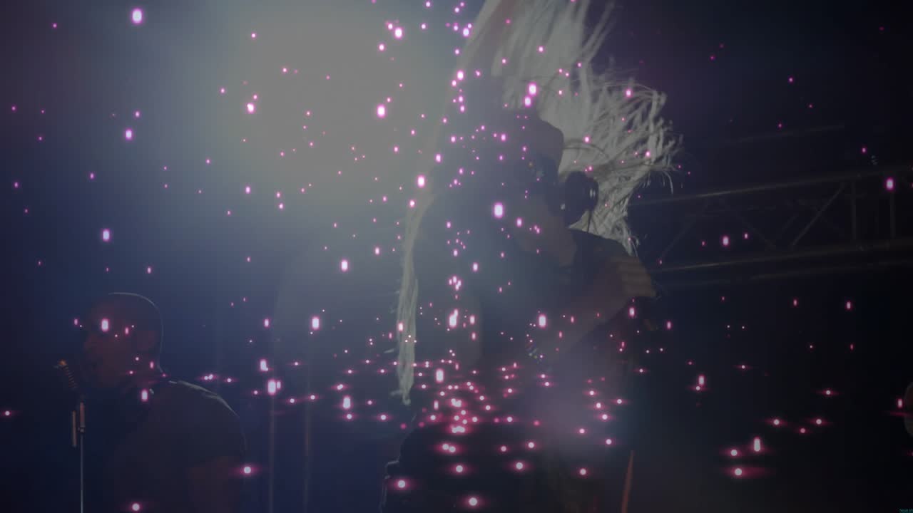 Concert music kicking, female singer headbanging and singing into mic with sparkles and harmony