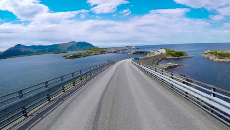 un coche que conduce en una carretera en noruega atlantic ocean road o la carretera atlántica (atlanterhavsveien) ha sido galardonado con el título de (construcción noruega del siglo).