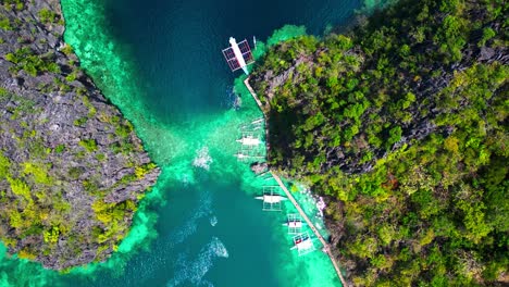 Kayangan-Lake-Aerial-Descend-Over-Docked-Boats-Next-To-A-Lagoon-Mountain