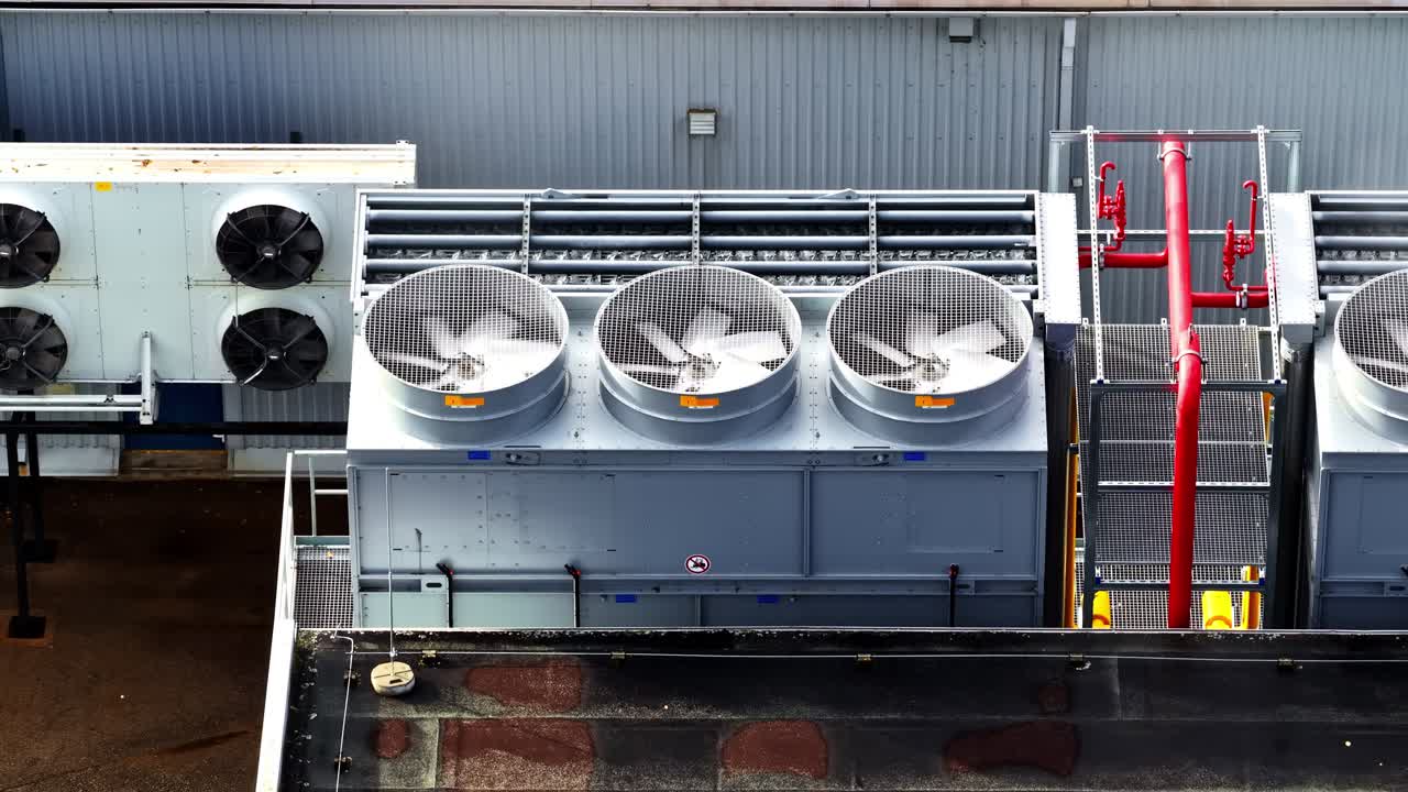 Close up of industrial building roof with fans and ventilation pipes, aerial