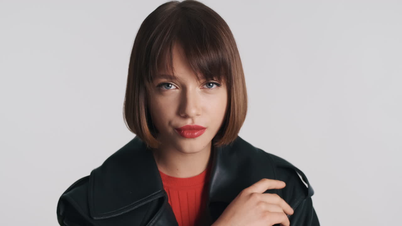 스타일리시한 프로 모델이 스튜디오에서 감각적으로 포즈를 취하고 있습니다.