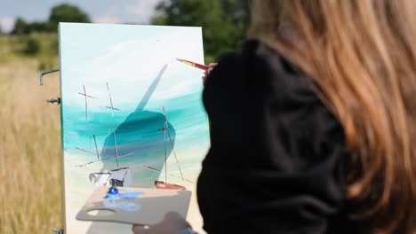at sunlight young artist painting with oil paint picture on canvas hold brush and palette in light - at sunlight young artist painting with oil paint picture on canvas hold brush and palette in light art studio. workspace. creative