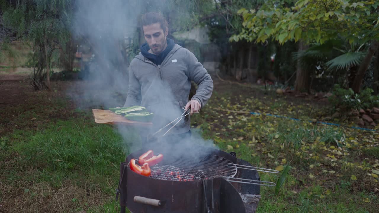 Man Grilling Vegetables in Garden