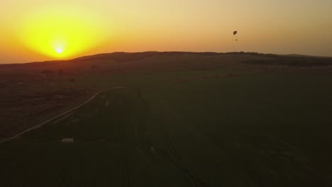 sonnenuntergang mit paragliding über feldern