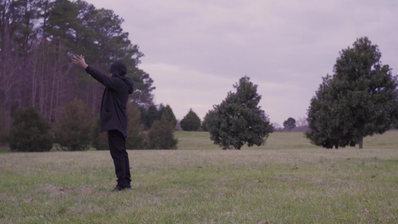 Male black Magician out in nature practicing wizardry. He is Walking as he invokes the forces beyond.