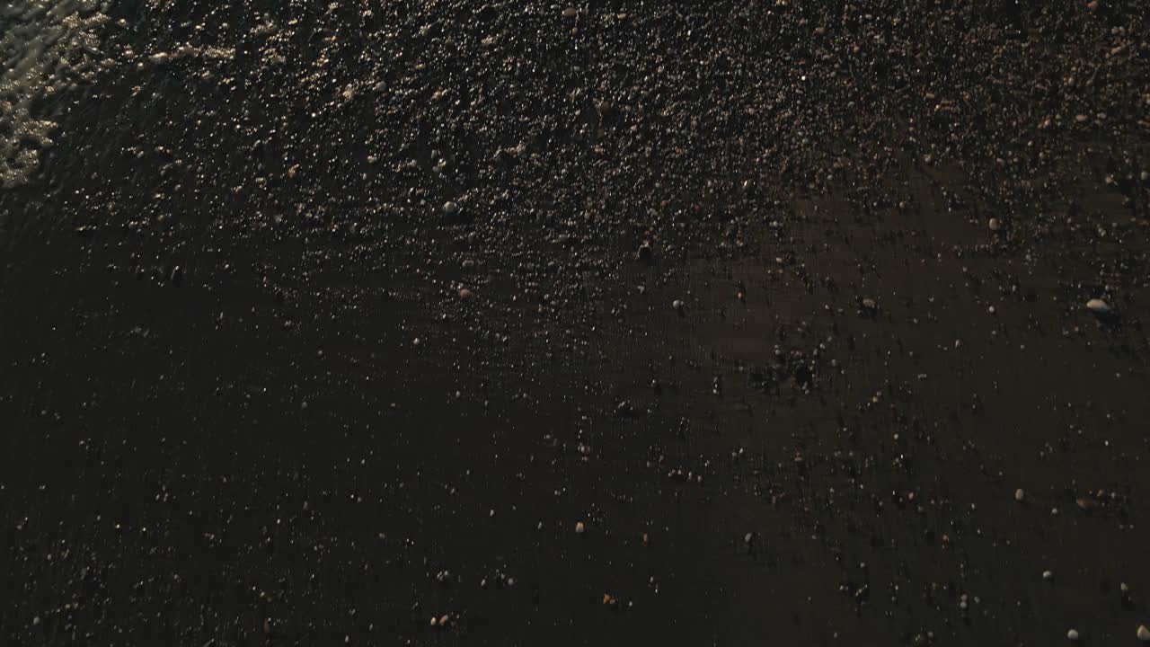 천천히 뒤로 움직이는 해변 모래의 세부 사항