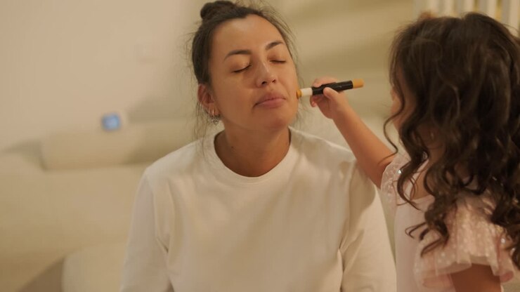 Little Girl Applying Makeup to Her Pregnant Mother at Home