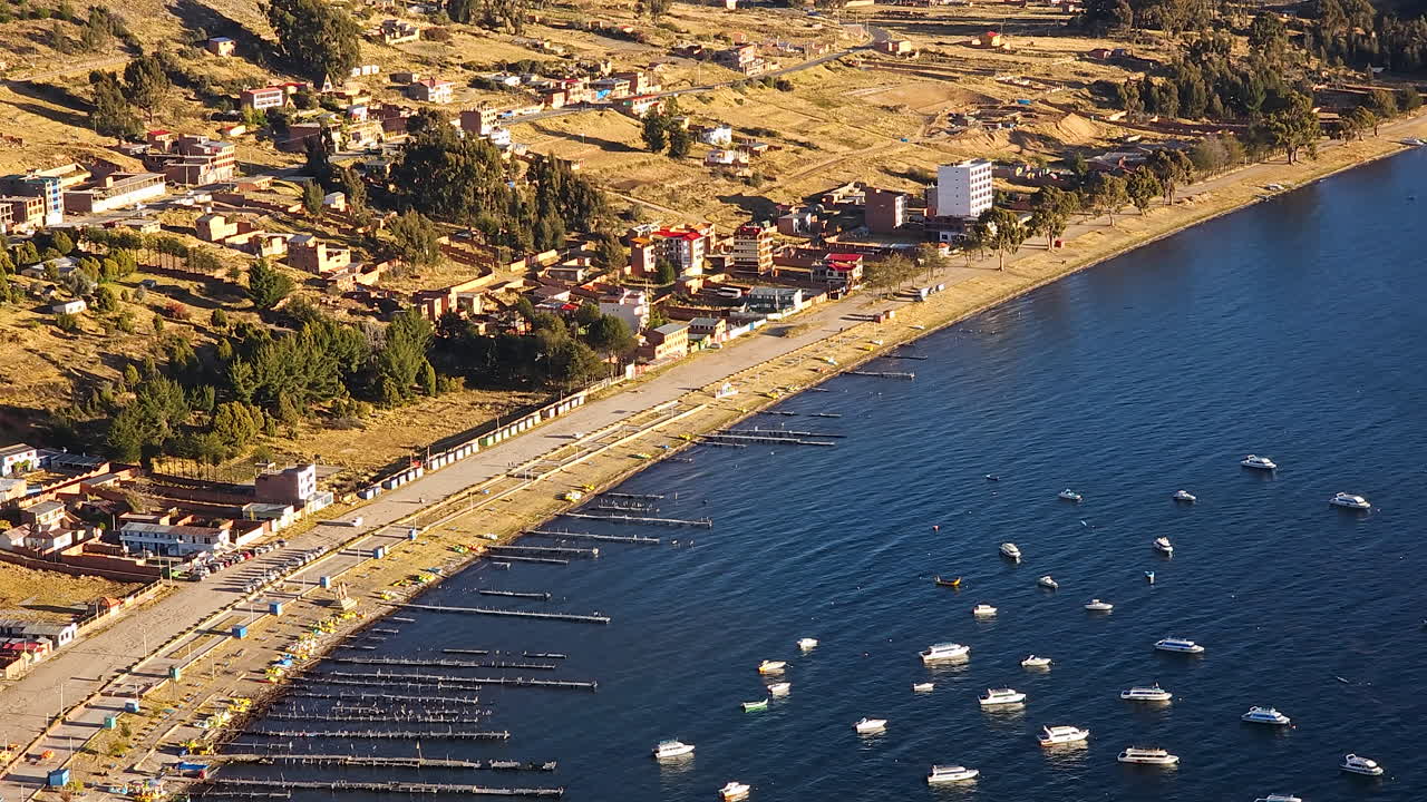 Experience a breathtaking aerial view of Copacabana Harbor, a picturesque tourist town in Bolivia, bathed in the warm glow of sunset