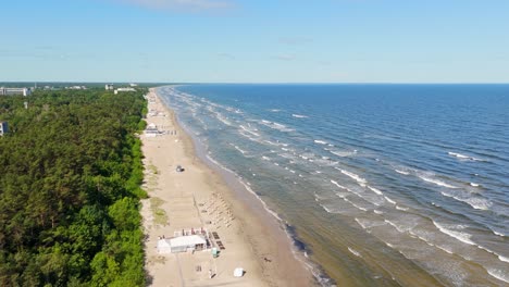 drone view of jurmala latvia sandy beach with waves and baltic sea forest coast