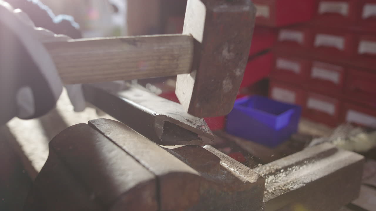Sharp points of metal post for storm protection hammered together on bench vice