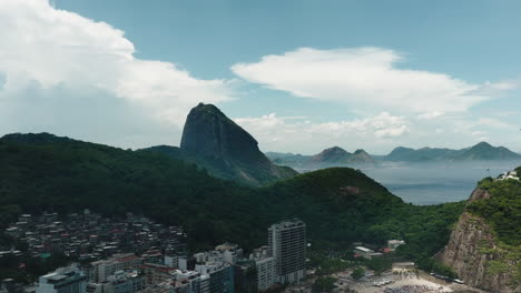 Aerial-tilt-down-fly-above-over-crowded-Copacabana-beach-and-Atlantic-ocean-coast-in-sunny-day