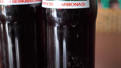 Slow motion shot of traditional Indonesian Badak glass bottles in a restaurant, close-up shot of the carbonated drink