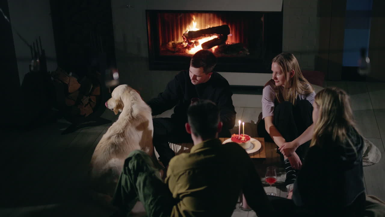 amigos celebrando su cumpleaños junto a la chimenea.