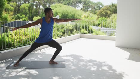 Hombre-Afroamericano-Practicando-Yoga-Haciendo-Ejercicio-En-La-Soleada-Terraza-Del-Jardín