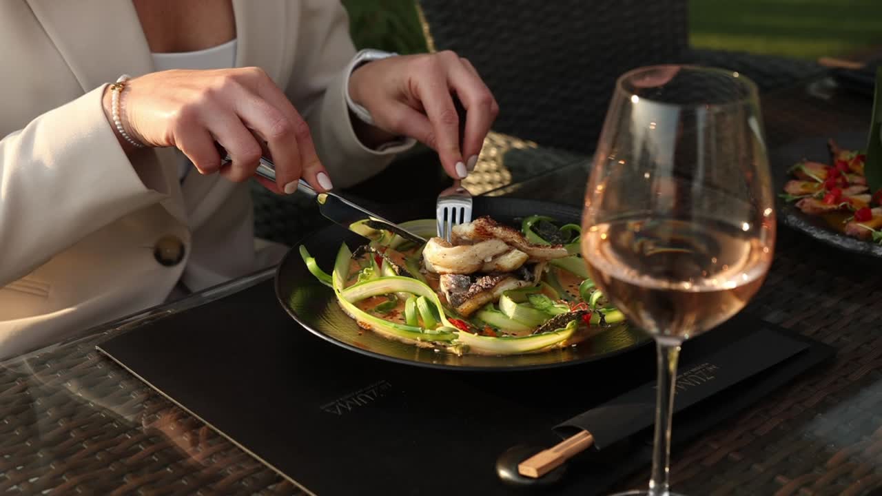 mujer comiendo un plato de pescado a la parrilla en un restaurante