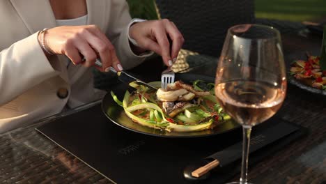 woman eating grilled fish dish at a restaurant