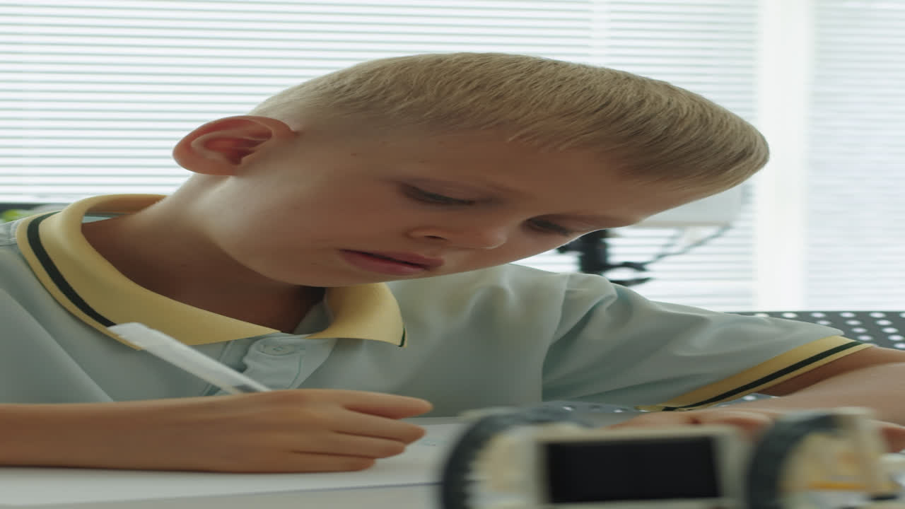 Boy of Elementary School Writing Test at Desk