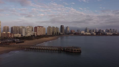 Filmische-Drohnenaufnahme-Mit-Anlegesteg-Und-Skyline-Des-Strandes-Punta-Del-Este-Bei-Sonnenuntergang-In-Uruguay