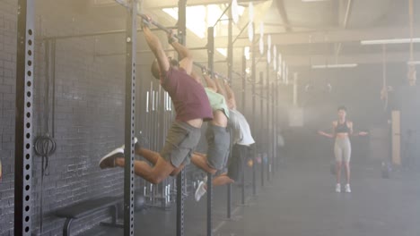 diverse male group fitness class training at gym doing pull ups on bars, in slow motion