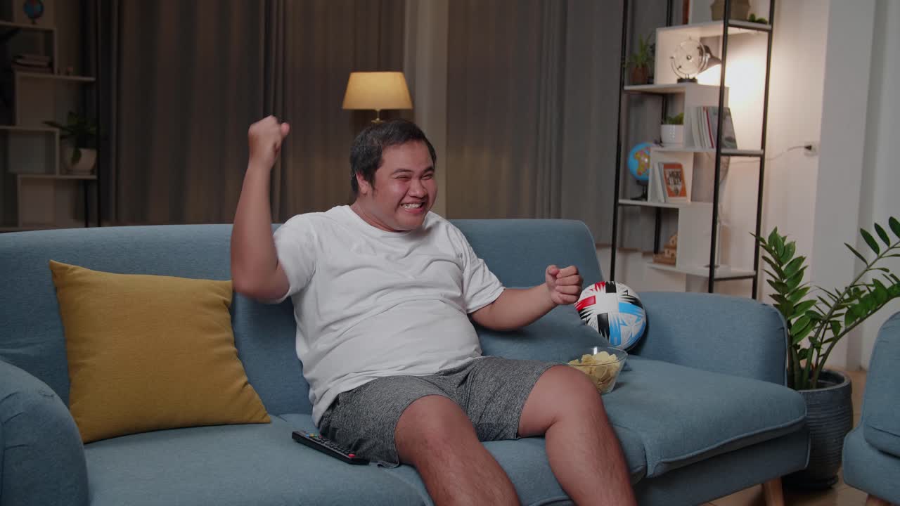 Asian Fat Man Watches Tv In The Room And Celebrating