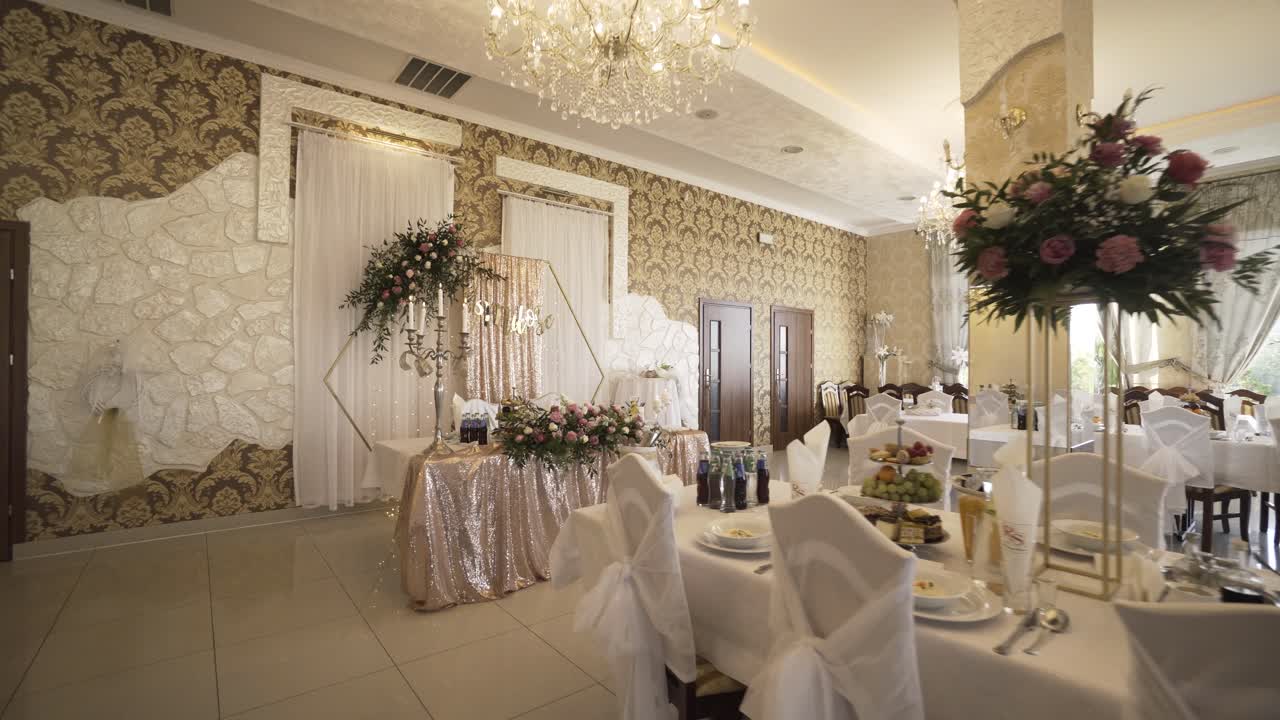 Interior de salón de bodas elegante y moderno, completamente decorado, mesas blancas, comida, cristal