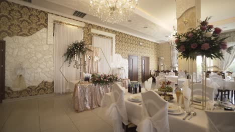 elegant and modern wedding hall interior, fully decorated, white tables, food, glass