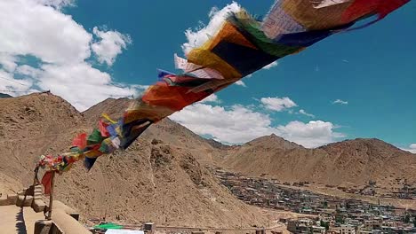 the-leh-city-with-house-made-of-mud-and-local-materials-crowded-the-Buddhist-flag-fluttering-due-to-winds-view-from-leh-palace