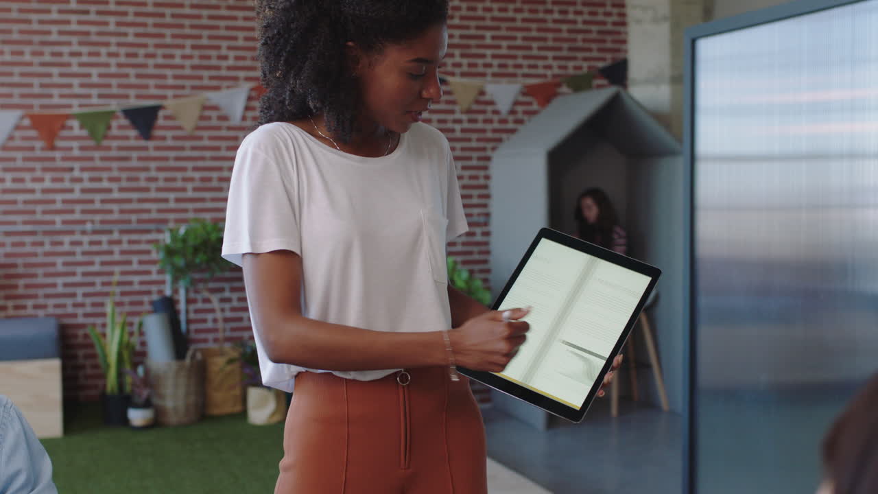 jóvenes empresarios se reúnen líder de equipo mujer presentando datos financieros utilizando una tableta mostrando colegas multiétnicos ideas de marketing en la presentación de la sala de juntas de la oficina