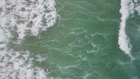 vista de arriba hacia abajo sobre las olas del océano a lo largo de la costa de cornualles en cámara lenta