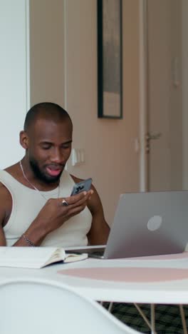 man working from home on a laptop and smartphone