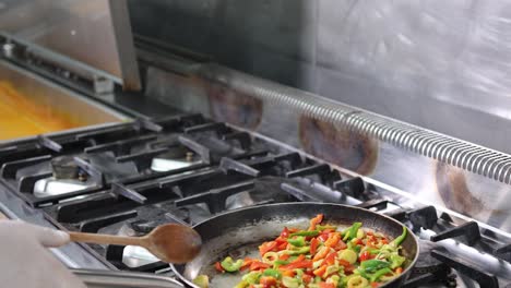 mixing sliced vegetable in a frying pan, close up