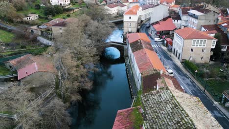 drone dolly aérea del río molgas y el puente romano cruzando el agua reflejo de los árboles y el cielo