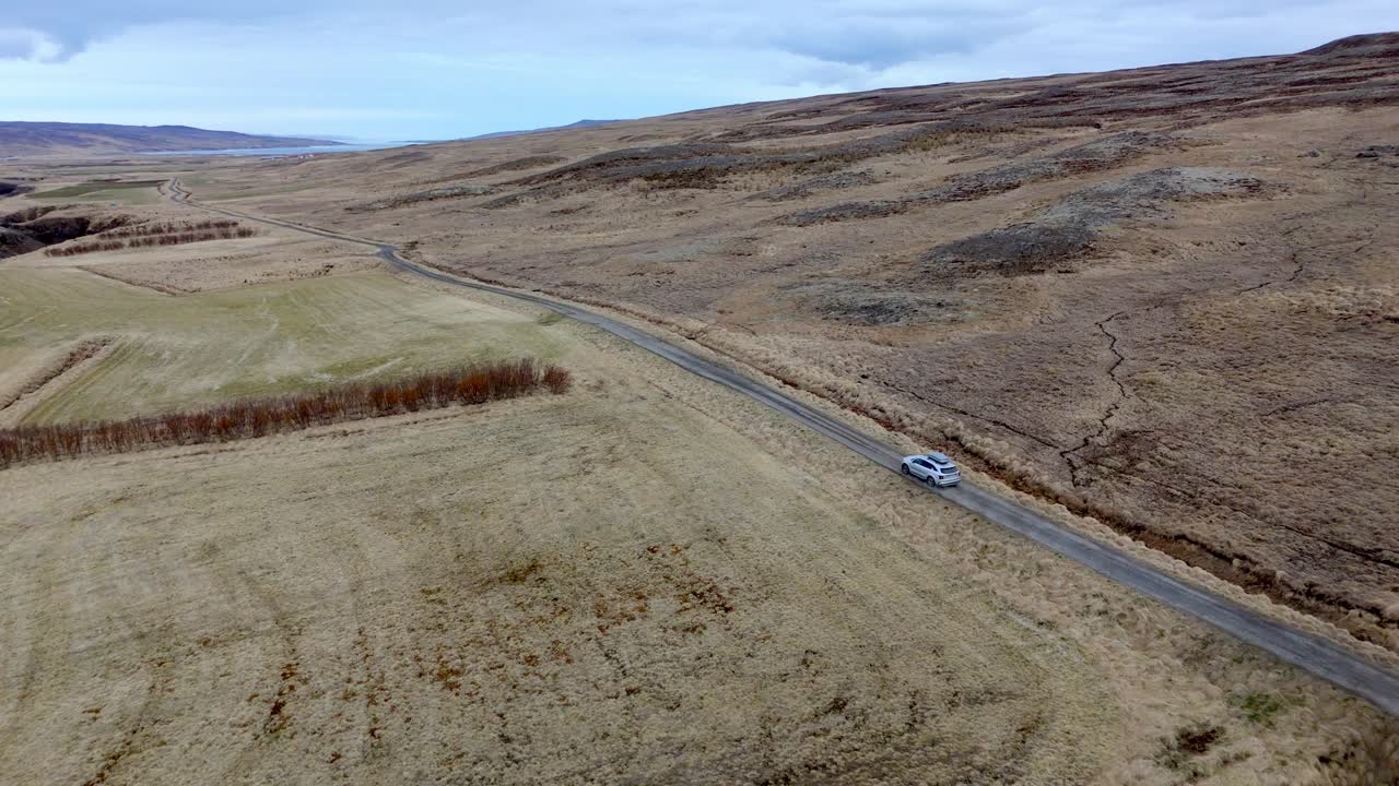 car with rooftop rack driving on a lonely Road in to the wilderness of Iceland during an adventure trip