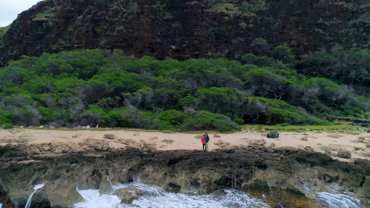 pareja mirando el mar desde la costa 4k
