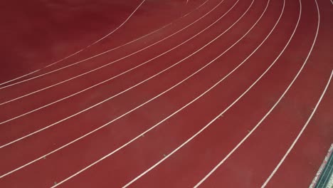 running track at the stadium, color is orange brick, high angle view by drone.