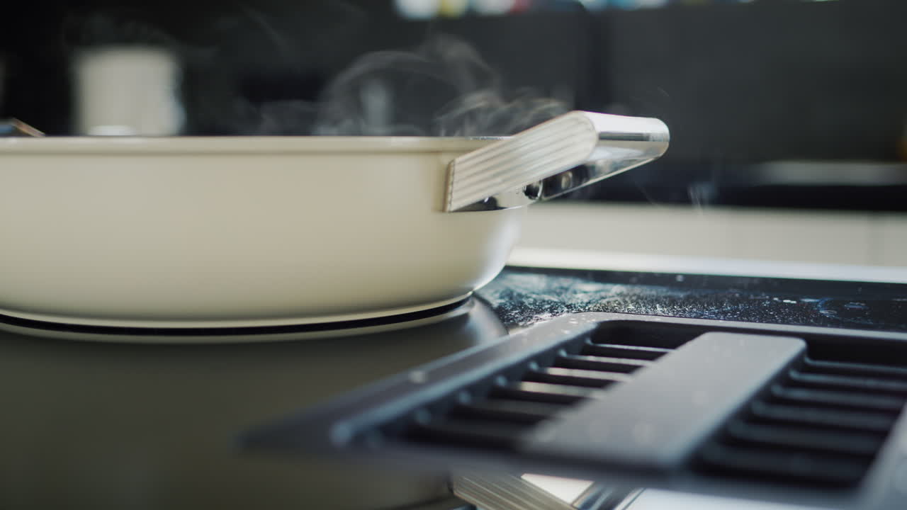 Food is cooked on a modern induction electric stove, the built-in hood sucks in steam