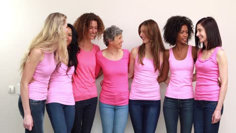 happy women with pink shirts standing