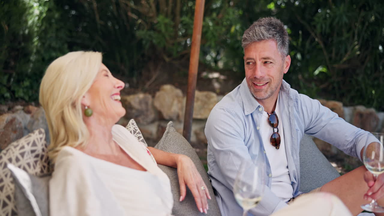 Happy Mature Couple Talking and Laughing Outdoors with Wine