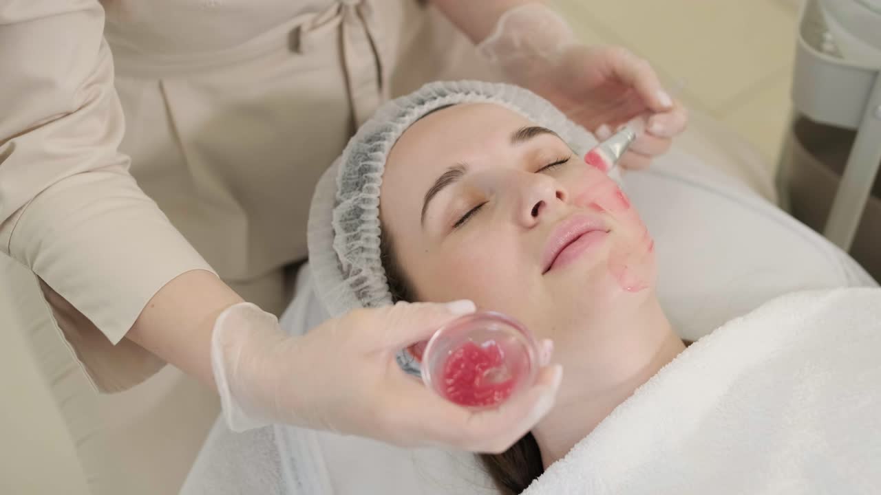 미용 전문가가 얼굴 치료와 얼굴 마스크를 적용합니다.