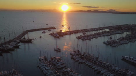 beautiful sunset drone shot of yacht harbor and sun reflection in the water